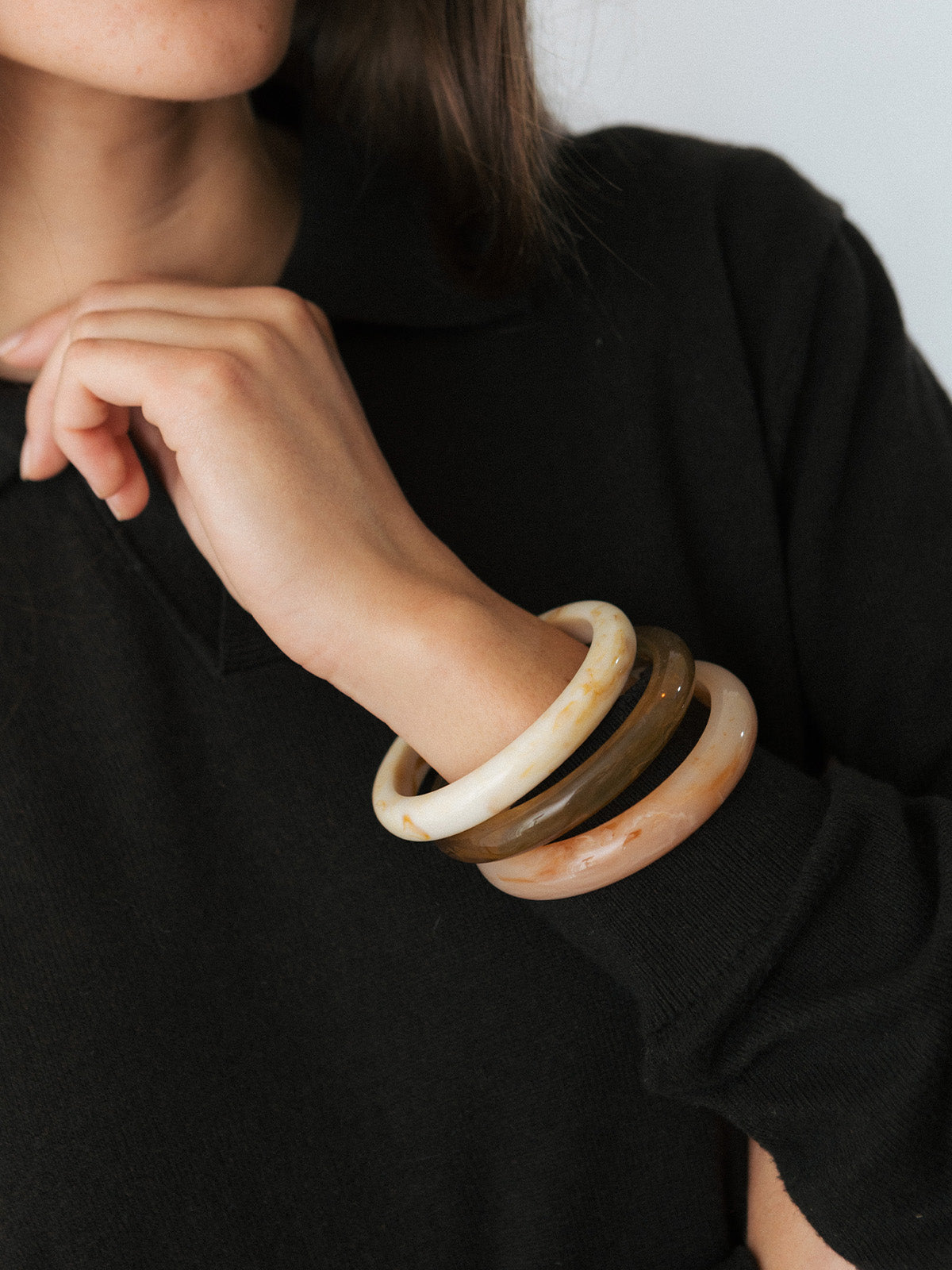 Ragazza che indossa bracciali in resina di diversi colori, fotografia close-up.