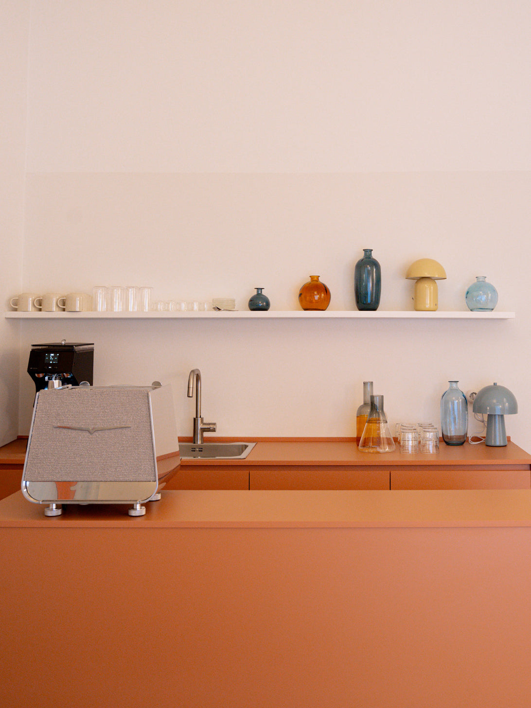 Angolo caffetteria del flagship store Collanine Colorate con macchina da caffè Victoria Arduino, tazze e arredi dello spazio showroom