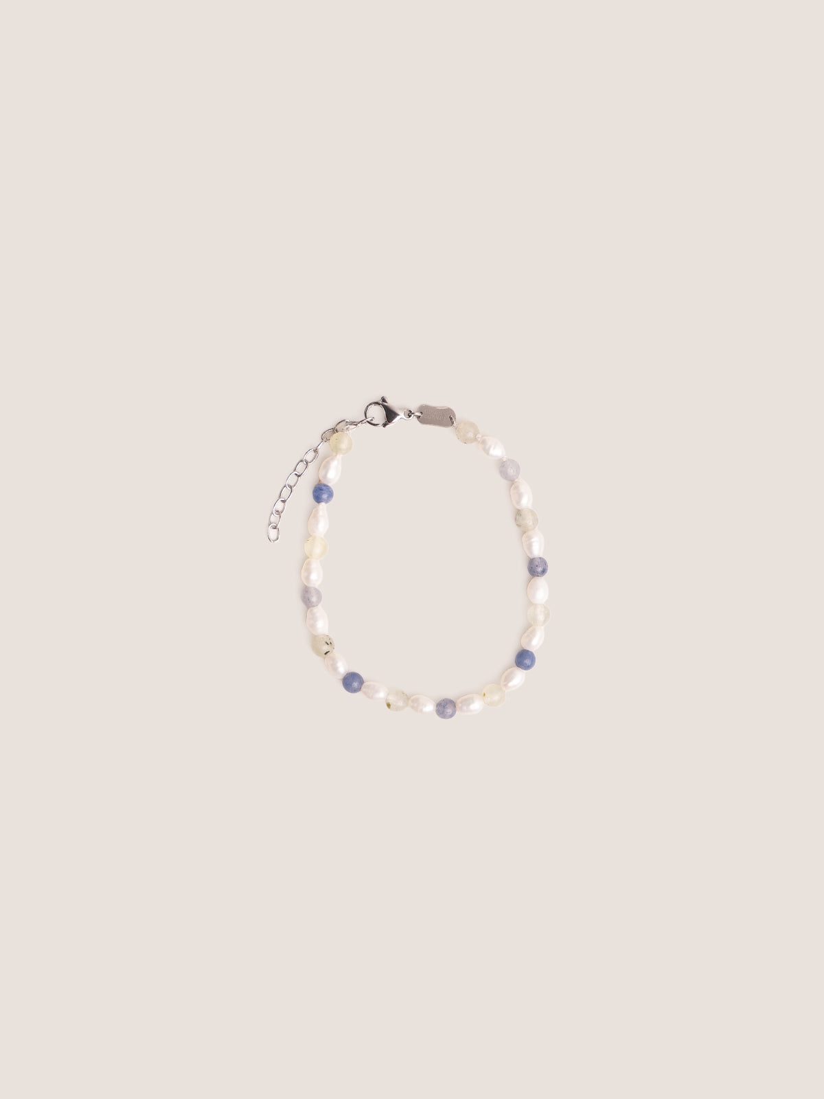 Bracciale realizzato con perle di fiume intervallate a sodalite e prenite, 
foto still life su sfondo neutro 