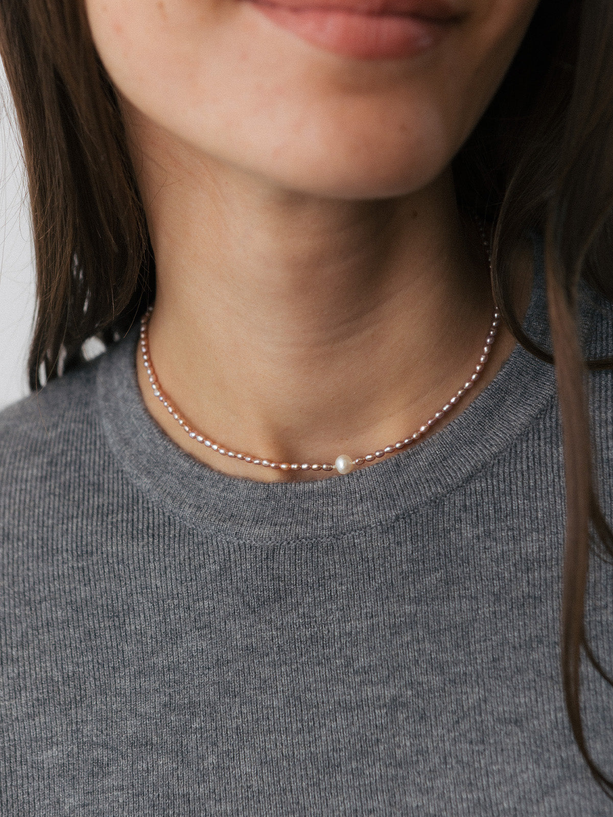 Girocollo con perle rosate e perla centrale bianca, foto close up indossata su modella