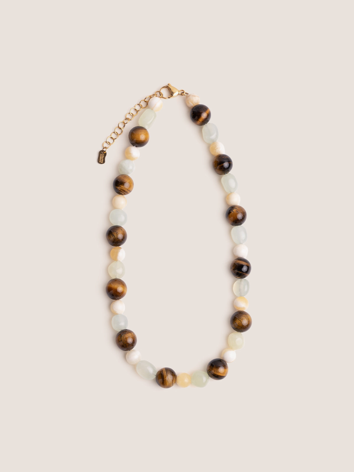 Collanina realizzata con un’alternanza di pietre dure tra cui occhio di tigre, madreperla e new jade e foto su sfondo bianco